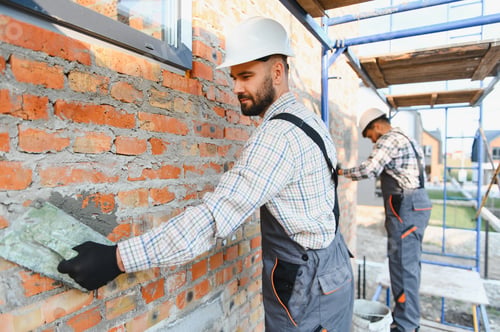 Preview: Construction worker plastering brick wall outdoor home renovation