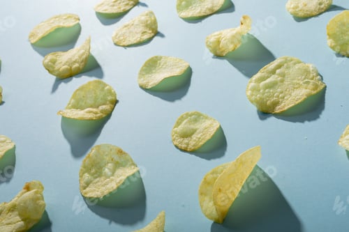 Preview: Full frame shot of potato chips arranged on blue background with shadow
