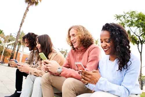 Preview: Friends having fun sharing in social media. Smiling mixed race group of friends sitting