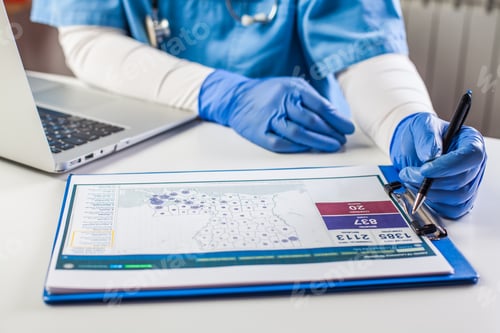 Preview: Doctor wearing protective gloves working on laptop computer
