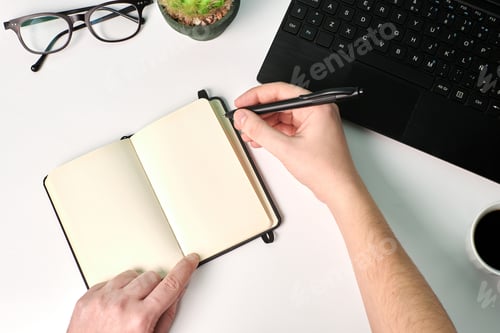 Preview: Man writes on a notebook on a white background. Business concept