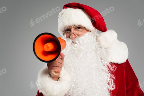 Preview: Santa claus in eyeglasses holding loudspeaker and looking at camera isolated on grey