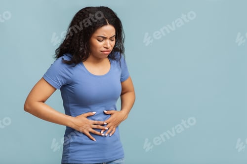 Preview: Food poisoning. Troubled african american woman touching stomach, suffering from abdominal pain