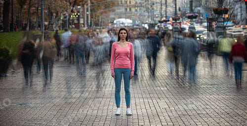 Preview: The young girl stands on the crowded urban street