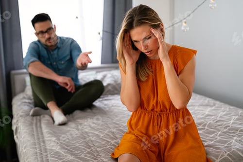 Preview: Worried Woman with Man Sitting Behind on Bed