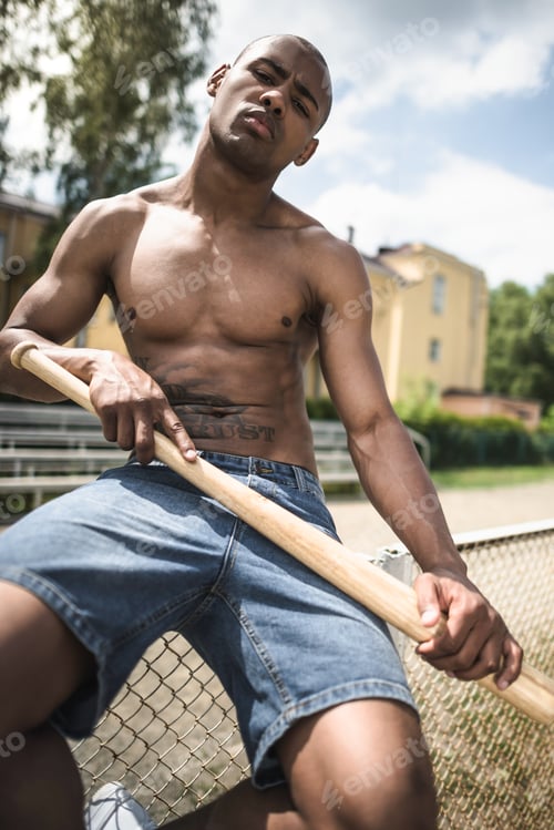 Preview: young handsome african american man posing with baseball bat on court