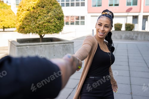 Preview: Young African American woman with braces pulling arm of girlfriend outside