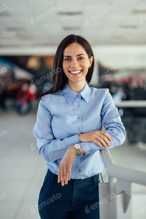 Preview: Portrait of a smiling brunette businesswoman, dressed elegantly, posing for a photo.