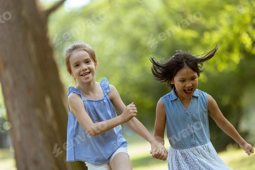 Preview: Caucasian and Asian girl running in the park