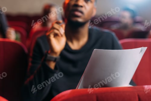 Preview: selective focus of multicultural young actor and actresses reading scripts in theater