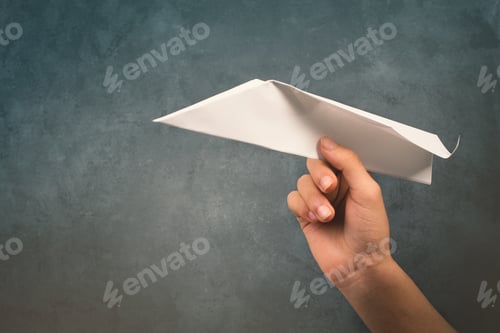 Preview: Holding a aper airplane in the handon a textured background