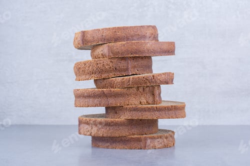 Preview: Brown bread slices stacked up on marble background