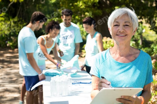Preview: Coach smiling while athletes registering for marathon