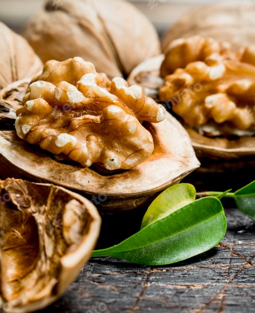 Preview: Shelled walnut with green leaves.