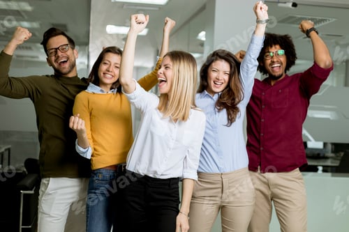 Preview: Group of young excited business people with hands up standing in office