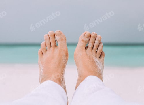 Preview: Male's legs on the white sand near the sea