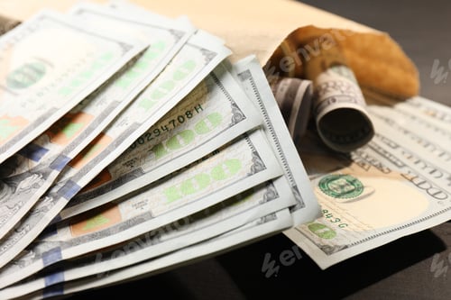 Preview: Paper money bag with dollar banknotes on table, closeup