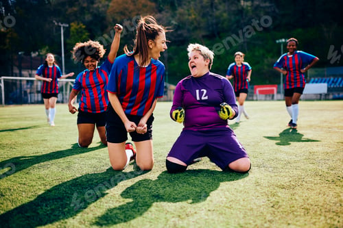 Preview: Soccer goalie and her teammates shouting out of joy after winning the match.