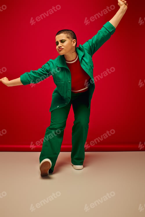 Preview: fashion statement, vibrant backdrop, funny and young woman in stylish attire posing on red