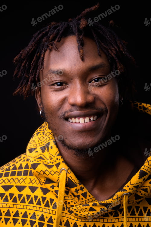 Preview: Young African man with dreadlocks against black background