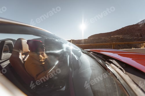 Preview: Woman traveling by cabriolet car on the desert road