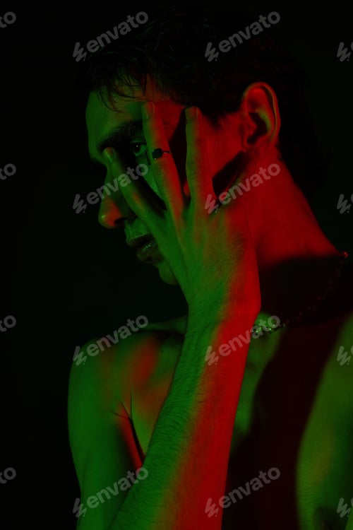 Preview: Stylish man posing dramatically with shadows and vibrant colors in an artistic setting