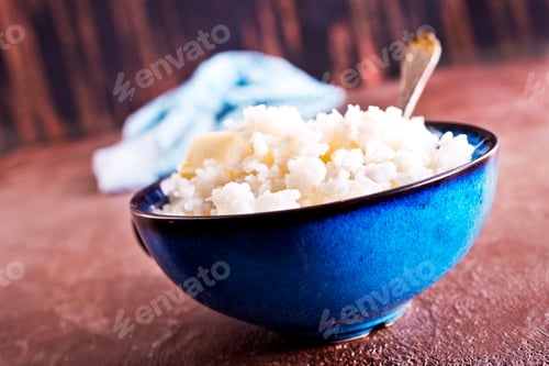 Preview: Delicious boiled rice in bowl on kitchen table