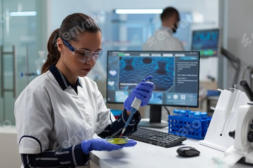 Preview: Biologist woman researcher putting liquid sample in petri dish using medical micropippete