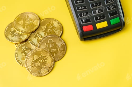 Preview: Bitcoin coins near POS payment terminal on the yellow background. Crypto currency for payment