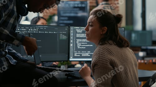 Preview: Junior programer sitting down on desk showing laptop with source code to senior dev