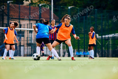 Preview: Women's soccer team having sports training on playing field.