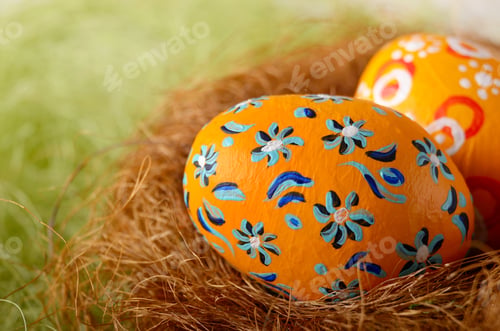 Preview: Painted easter eggs in the nest on green background