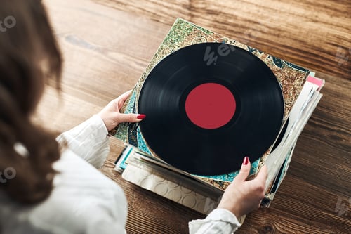 Preview: Young woman listening to music from vinyl record. Playing music on turntable player. Retro vintage