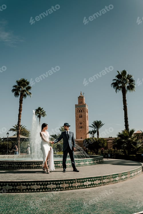Preview: a couple dressed as brides posing in front of the Koutoubia mosque in Morocco.