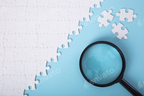 Preview: Set of puzzle pieces with magnifying glass background.