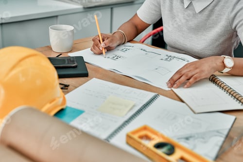 Preview: Closeup shot of an unrecognisable architect working with blueprints in an office