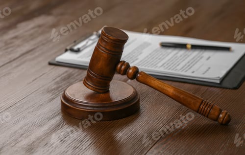 Preview: Wooden gavel near clipboard with documents on table. Law and justice