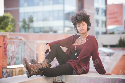 Preview: beautiful black curly hair african woman listening music with headphones