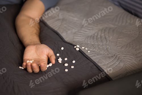 Preview: Hand with a lot of pills on the bed