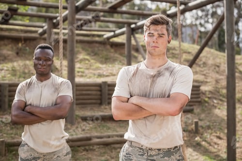 Preview: Military man standing with arms crossed during obstacle course in boot camp
