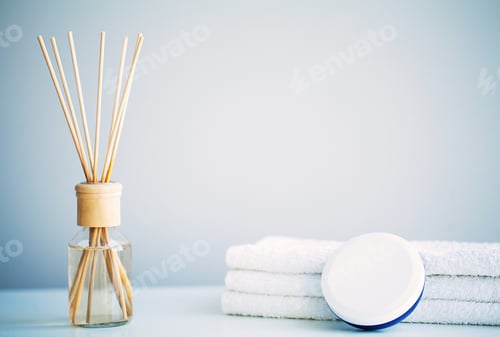 Preview: Spa concept. Moisturizing cream, towels and aroma oil on table in bath room