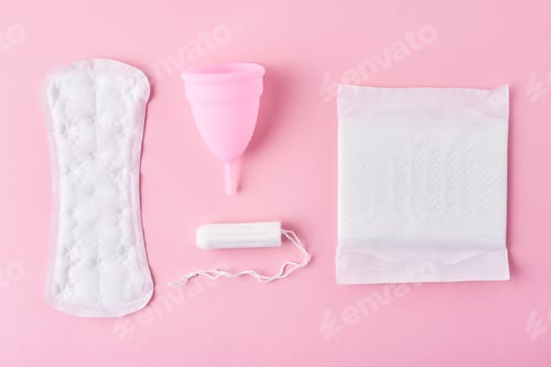 Preview: Sanitary pad, menstrual cup and tampon on a pink background, top view