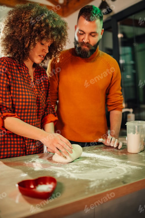 Preview: Couple kneading dough, making pizza or bread together in kitchen
