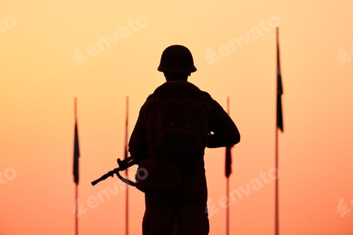 Preview: Rear view of silhouette of soldier in military gear holds weapon against bloody sunset