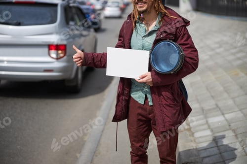 Preview: Positive delighted street musician waiting for car