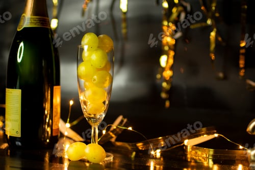 Preview: End of the year concept. Glass of champagne with grapes inside