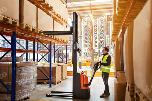 Preview: Employee working on warehouse with boxes on shelves. Worker operator using reach truck