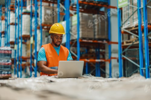 Preview: Warehouse worker using laptop checking inventory in distribution center