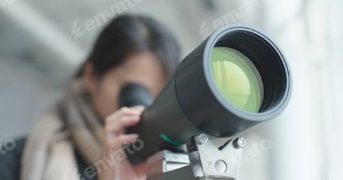 Preview: Woman looking though the telescope