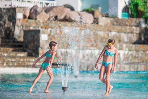 Preview: Adorable little girls playing in outdoor swimming pool